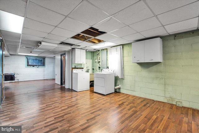 basement featuring dark hardwood / wood-style flooring, a paneled ceiling, and washer and clothes dryer