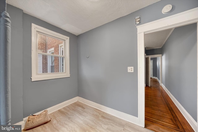 unfurnished room with hardwood / wood-style floors and a textured ceiling