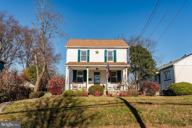 view of front of house with covered porch and a front yard