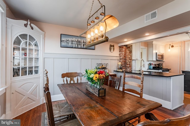 dining space featuring a chandelier, dark wood-type flooring, and sink