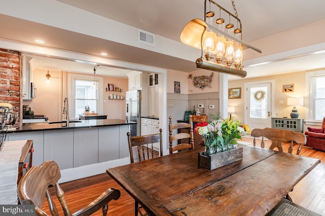 dining area with a chandelier, sink, and light hardwood / wood-style floors