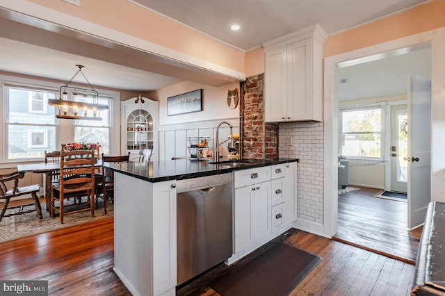 kitchen with white cabinetry, dishwasher, hanging light fixtures, dark hardwood / wood-style floors, and decorative backsplash