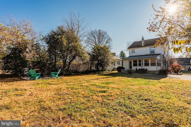 view of yard with a sunroom and a fire pit