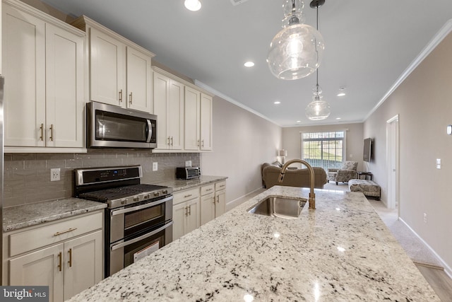 kitchen featuring light stone countertops, sink, hanging light fixtures, stainless steel appliances, and crown molding