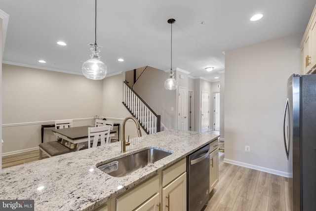 kitchen with light hardwood / wood-style floors, light stone countertops, hanging light fixtures, and appliances with stainless steel finishes