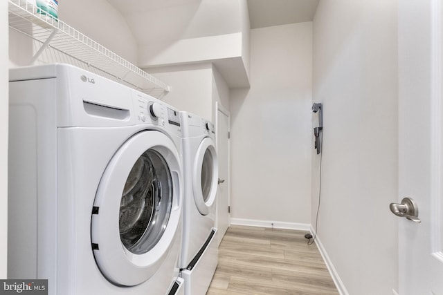 laundry room featuring light hardwood / wood-style floors and washing machine and clothes dryer