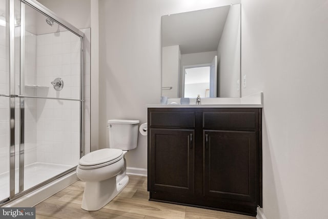 bathroom featuring hardwood / wood-style floors, vanity, toilet, and walk in shower