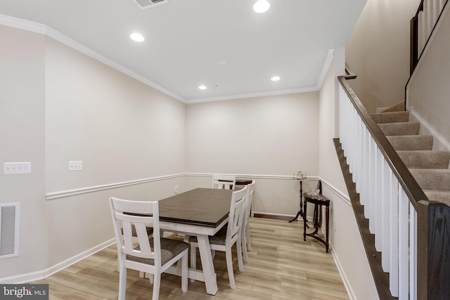 dining room with light wood-type flooring and ornamental molding