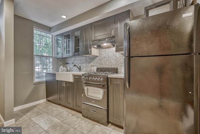 510 Druid Hill Ave, Baltimore, MD 21201 - kitchen featuring freestanding refrigerator, gas stove, under cabinet range hood, a sink, and baseboards