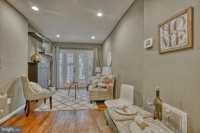 living area with light hardwood / wood-style flooring and french doors