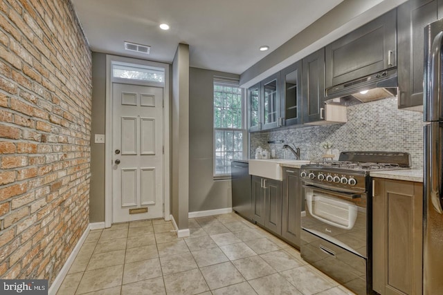 510 Druid Hill Ave, Baltimore, MD 21201 - kitchen with under cabinet range hood, gas stove, a sink, backsplash, and baseboards