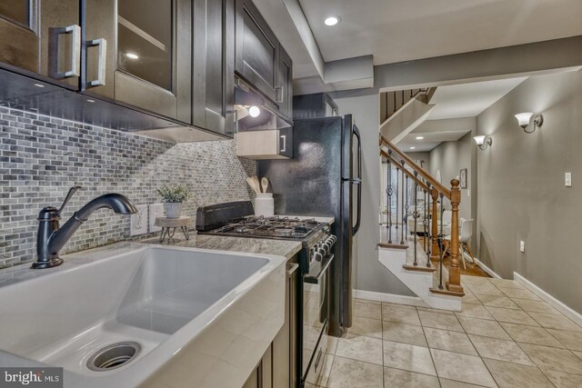 510 Druid Hill Ave, Baltimore, MD 21201 - kitchen with stainless steel range with gas cooktop, a sink, backsplash, light tile patterned floors, and glass insert cabinets