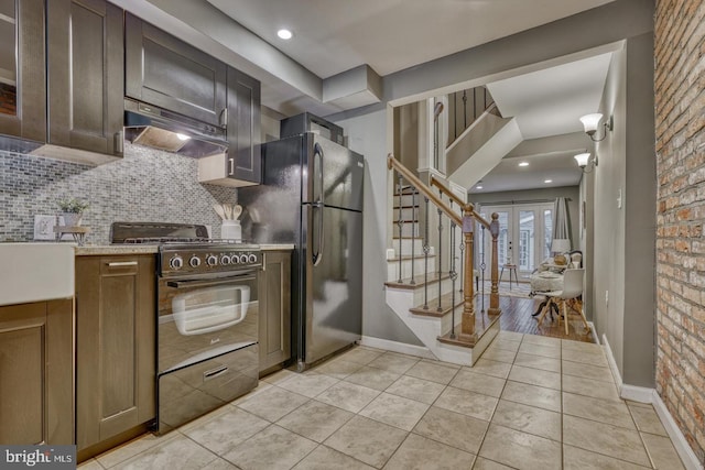 510 Druid Hill Ave, Baltimore, MD 21201 - kitchen with under cabinet range hood, black range with gas cooktop, freestanding refrigerator, light tile patterned floors, and backsplash