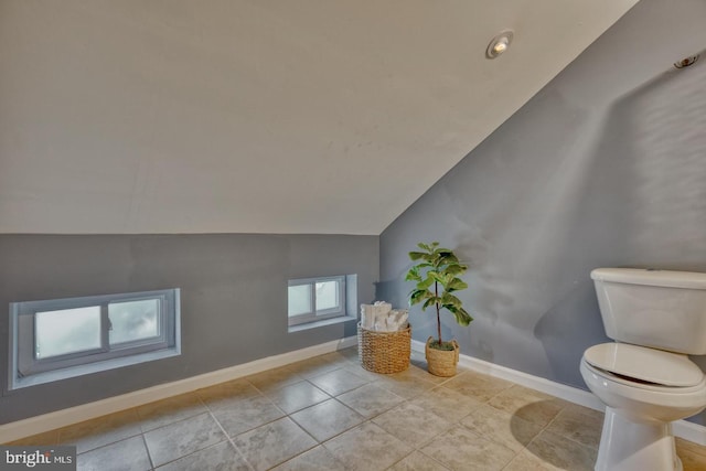 bathroom with tile patterned floors, toilet, and lofted ceiling