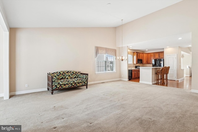 sitting room featuring light carpet, a notable chandelier, and vaulted ceiling