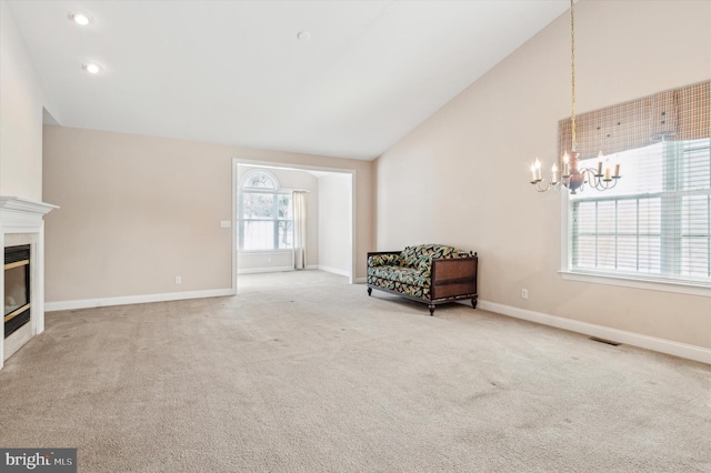 sitting room featuring carpet flooring, an inviting chandelier, and lofted ceiling