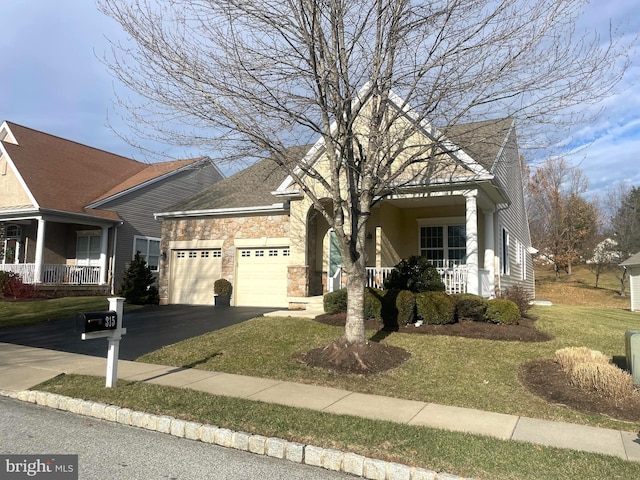 view of front facade with a garage, a front lawn, and a porch