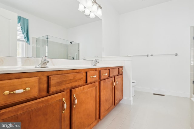 bathroom with tile patterned floors, toilet, vanity, and walk in shower