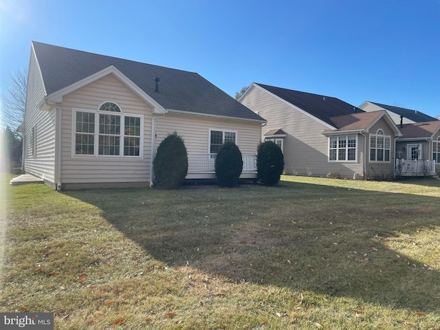 rear view of property featuring a lawn