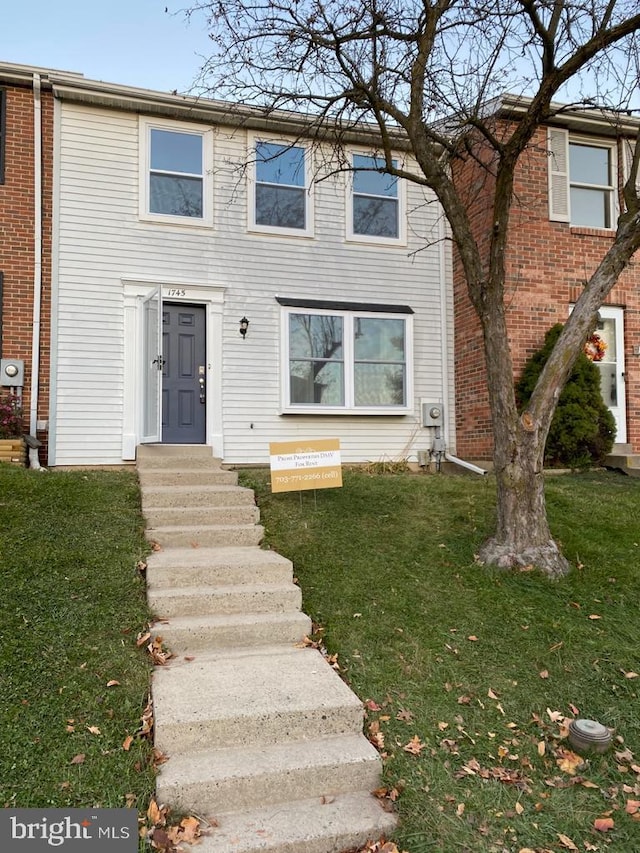 view of property featuring a front lawn