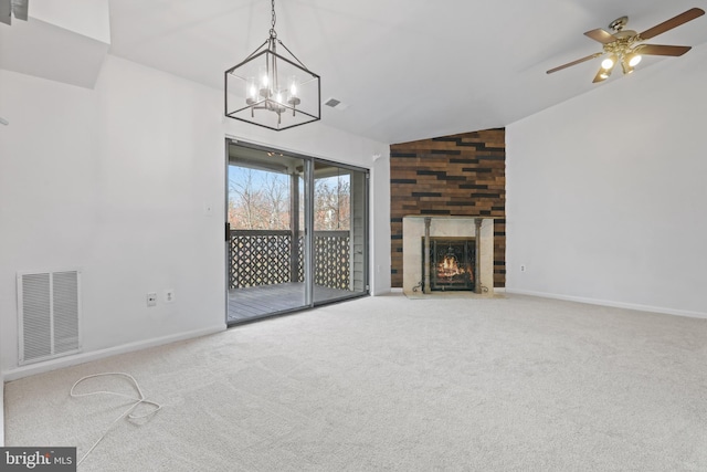 unfurnished living room featuring carpet flooring, ceiling fan with notable chandelier, lofted ceiling, and a tiled fireplace