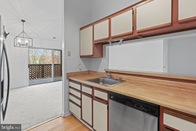 kitchen featuring sink, hanging light fixtures, appliances with stainless steel finishes, a notable chandelier, and white cabinetry