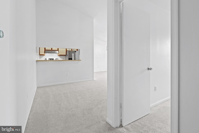 hallway featuring light colored carpet