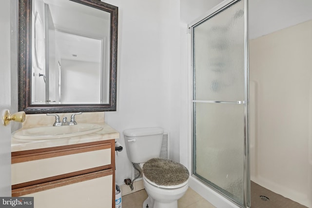 bathroom featuring tile patterned floors, vanity, a shower with shower door, and toilet