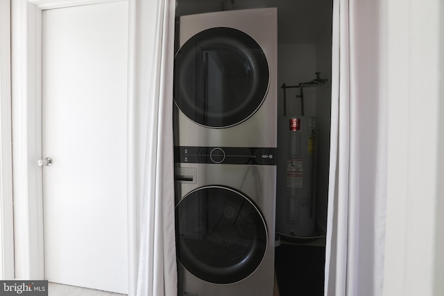 laundry area featuring water heater and stacked washer and clothes dryer