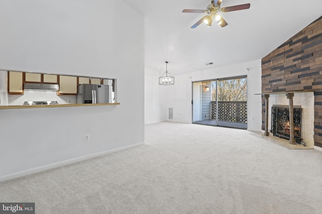 unfurnished living room featuring ceiling fan, a large fireplace, light carpet, and high vaulted ceiling