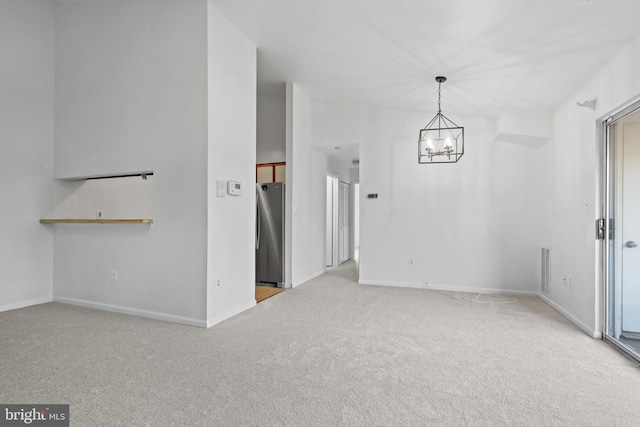 carpeted spare room with a chandelier