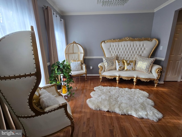 living area with wood-type flooring and crown molding