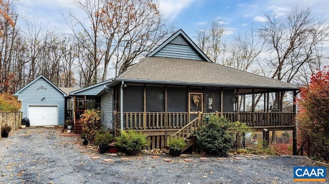 view of front facade with an outbuilding, a garage, and a sunroom