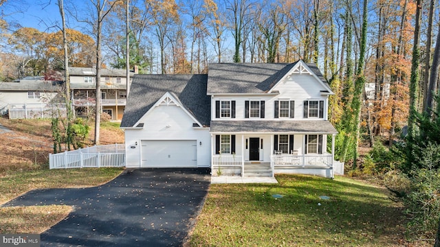 view of front facade featuring a porch, a garage, and a front lawn