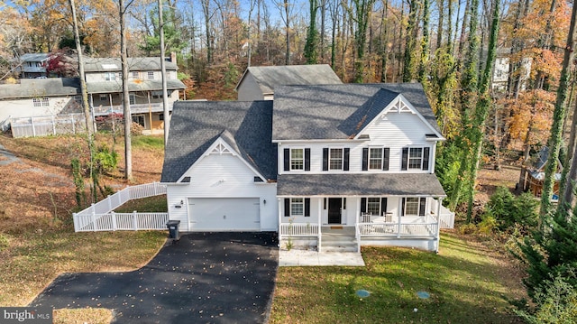 view of front facade with a front yard, a porch, and a garage