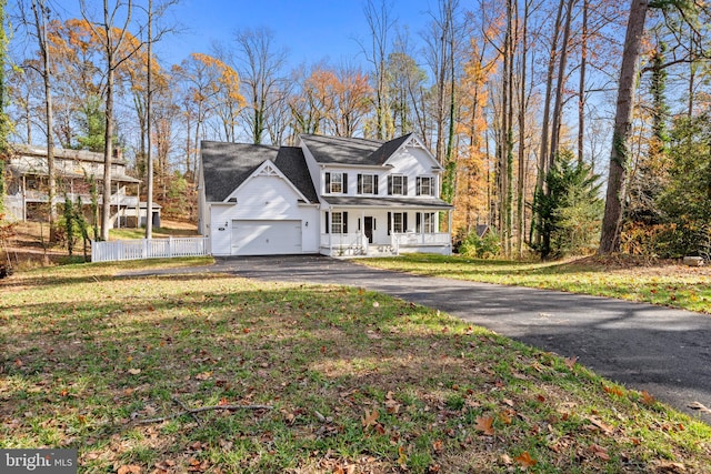 view of front of property with covered porch, a garage, and a front yard