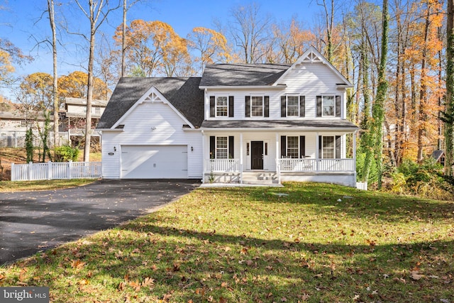 view of front of property featuring a garage, covered porch, and a front lawn