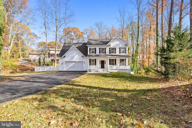 view of front of house with a porch, a garage, and a front lawn