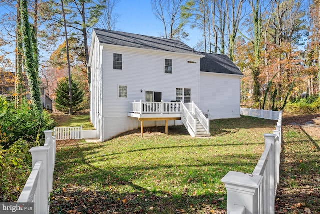 rear view of property with a lawn and a wooden deck