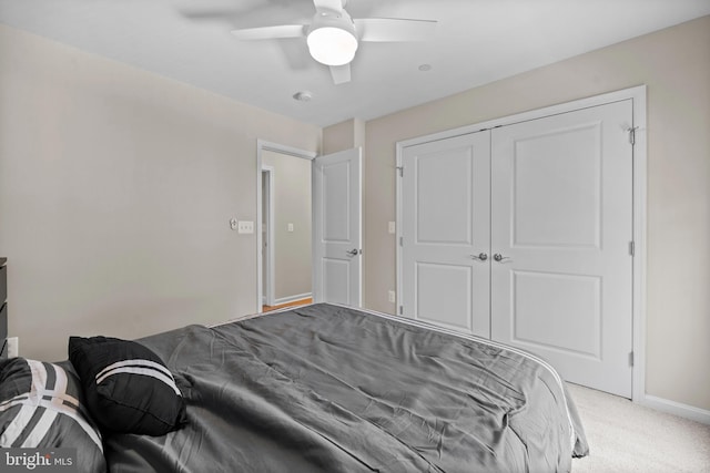 carpeted bedroom featuring ceiling fan and a closet