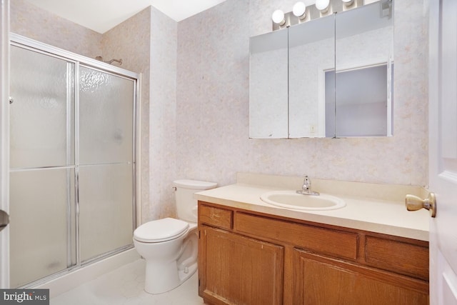 bathroom featuring tile patterned flooring, vanity, toilet, and a shower with door