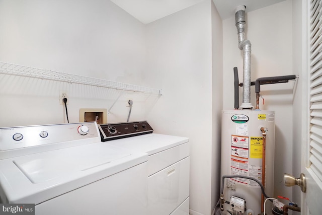 clothes washing area with washer and dryer and gas water heater