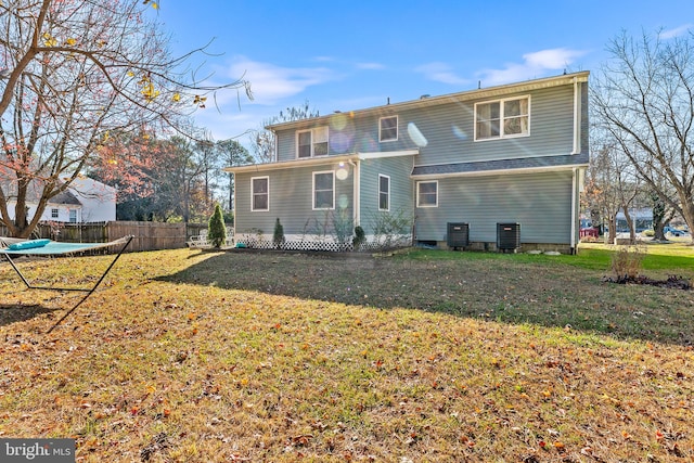 back of house featuring a yard and central AC