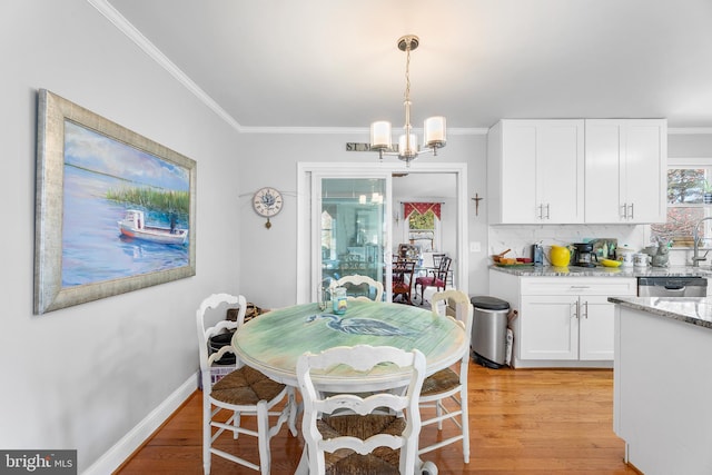 dining room featuring a chandelier, light hardwood / wood-style flooring, and crown molding