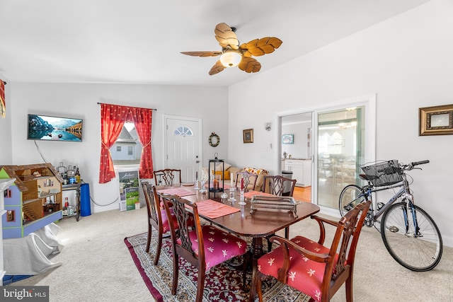 carpeted dining space with ceiling fan, plenty of natural light, and lofted ceiling