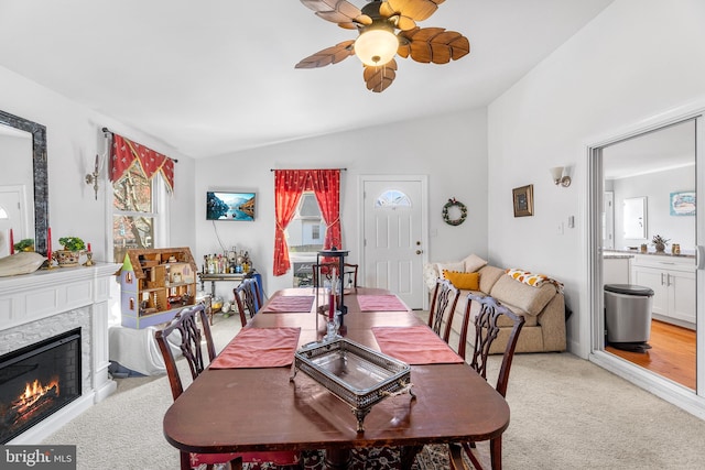 carpeted dining room with vaulted ceiling and ceiling fan