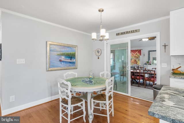 dining space featuring an inviting chandelier, light hardwood / wood-style flooring, and ornamental molding