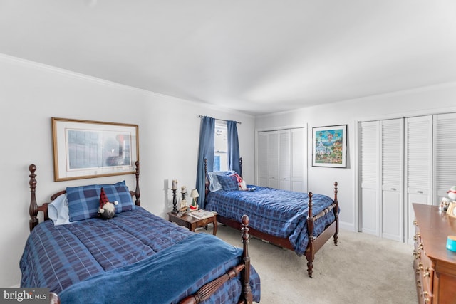 carpeted bedroom with multiple closets and ornamental molding