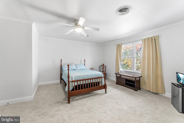 carpeted bedroom with ceiling fan and ornamental molding