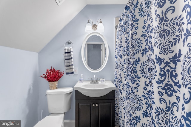 bathroom featuring vanity, lofted ceiling, and toilet